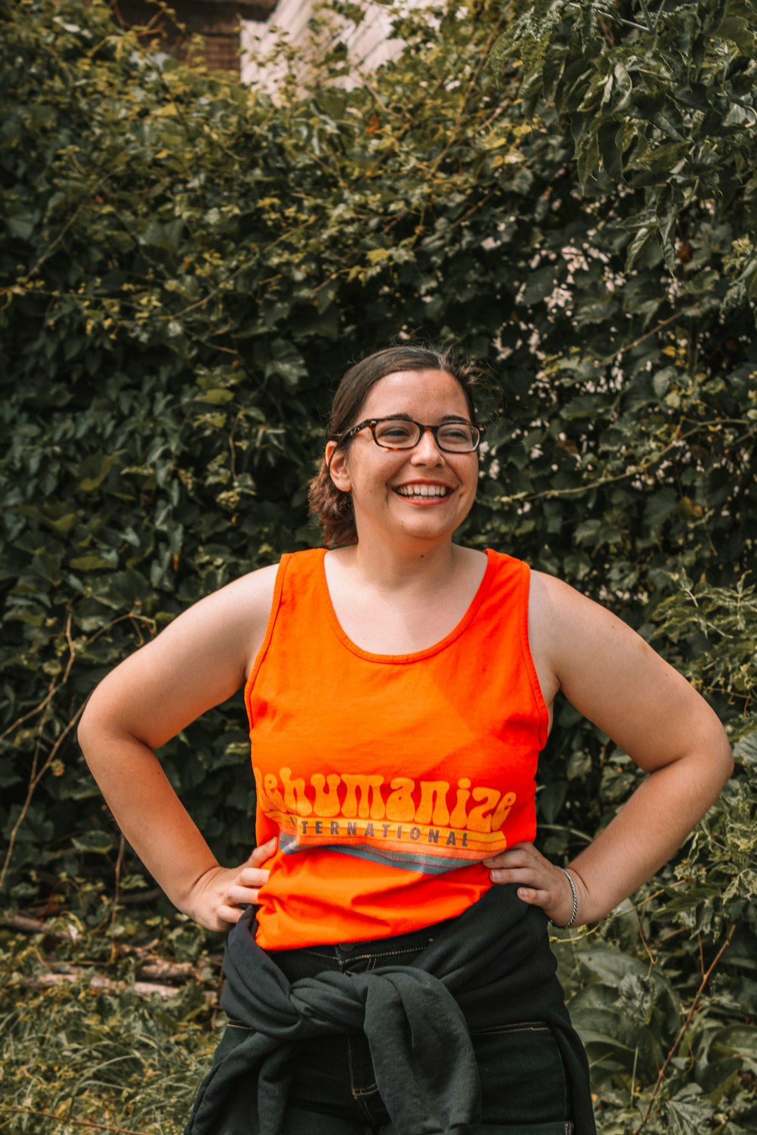 woman in orange tank top and red shorts smiling