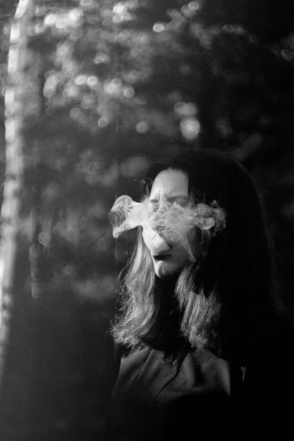 grayscale photo of woman with white flower on her face