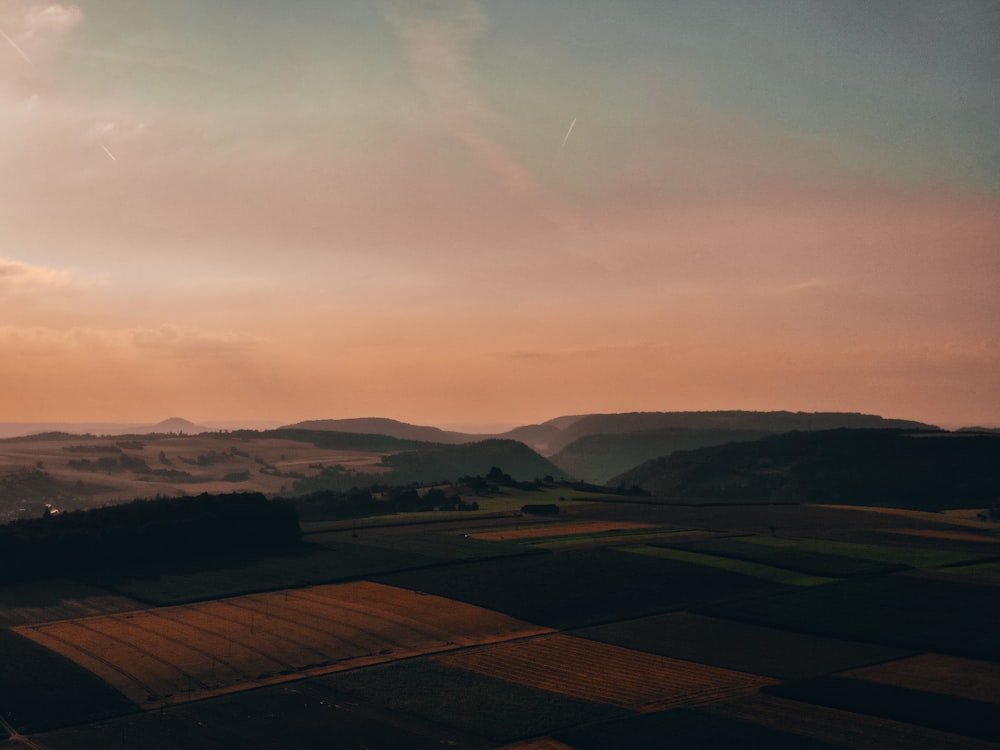 brown field under white clouds during daytime