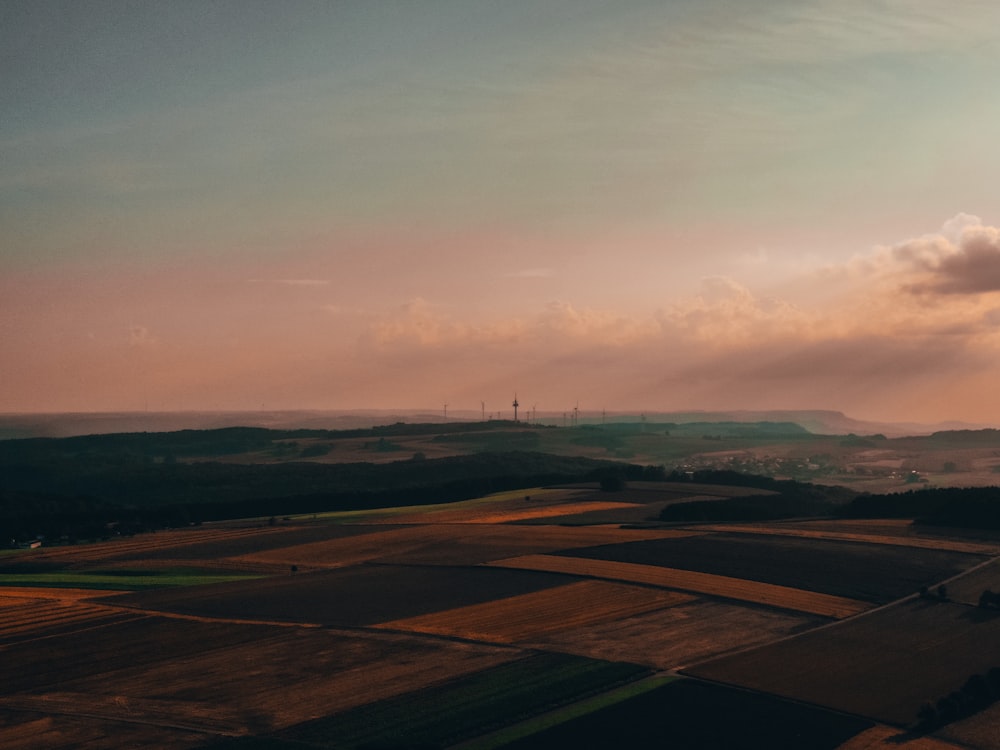 Champ d’herbe verte sous un ciel nuageux pendant la journée