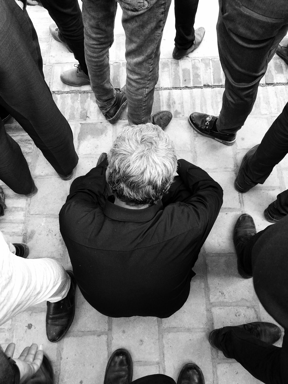 man in black jacket and pants sitting on floor