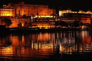 brown concrete building near body of water during night time