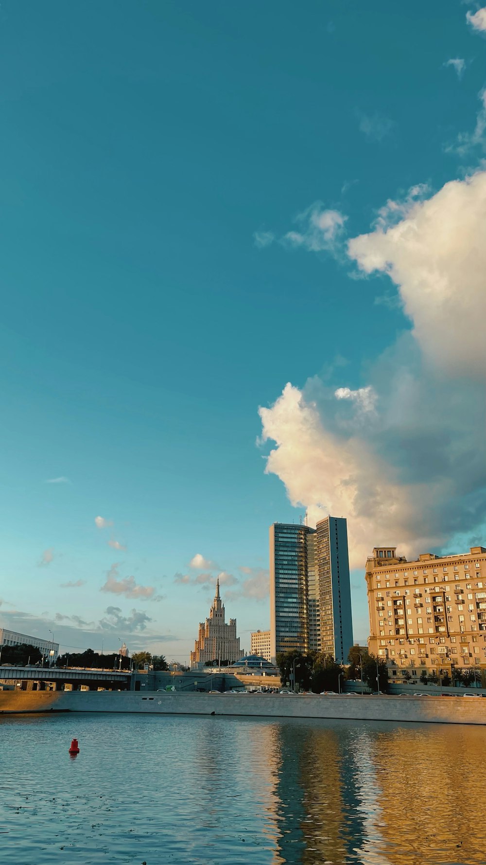city buildings under blue sky and white clouds during daytime