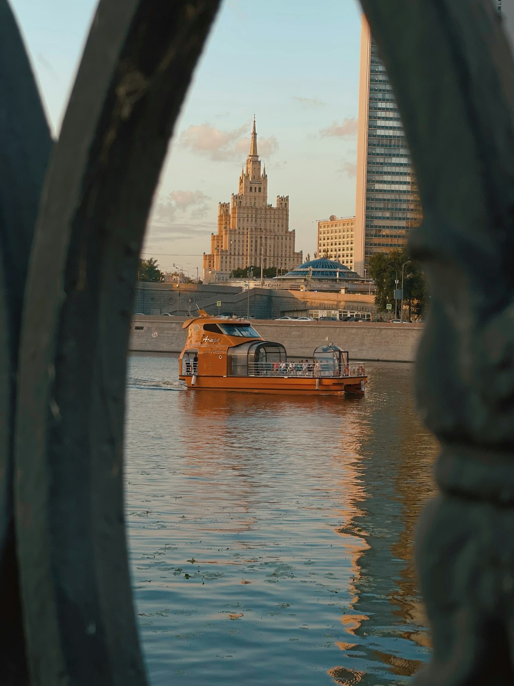 brown boat on water near city buildings during daytime