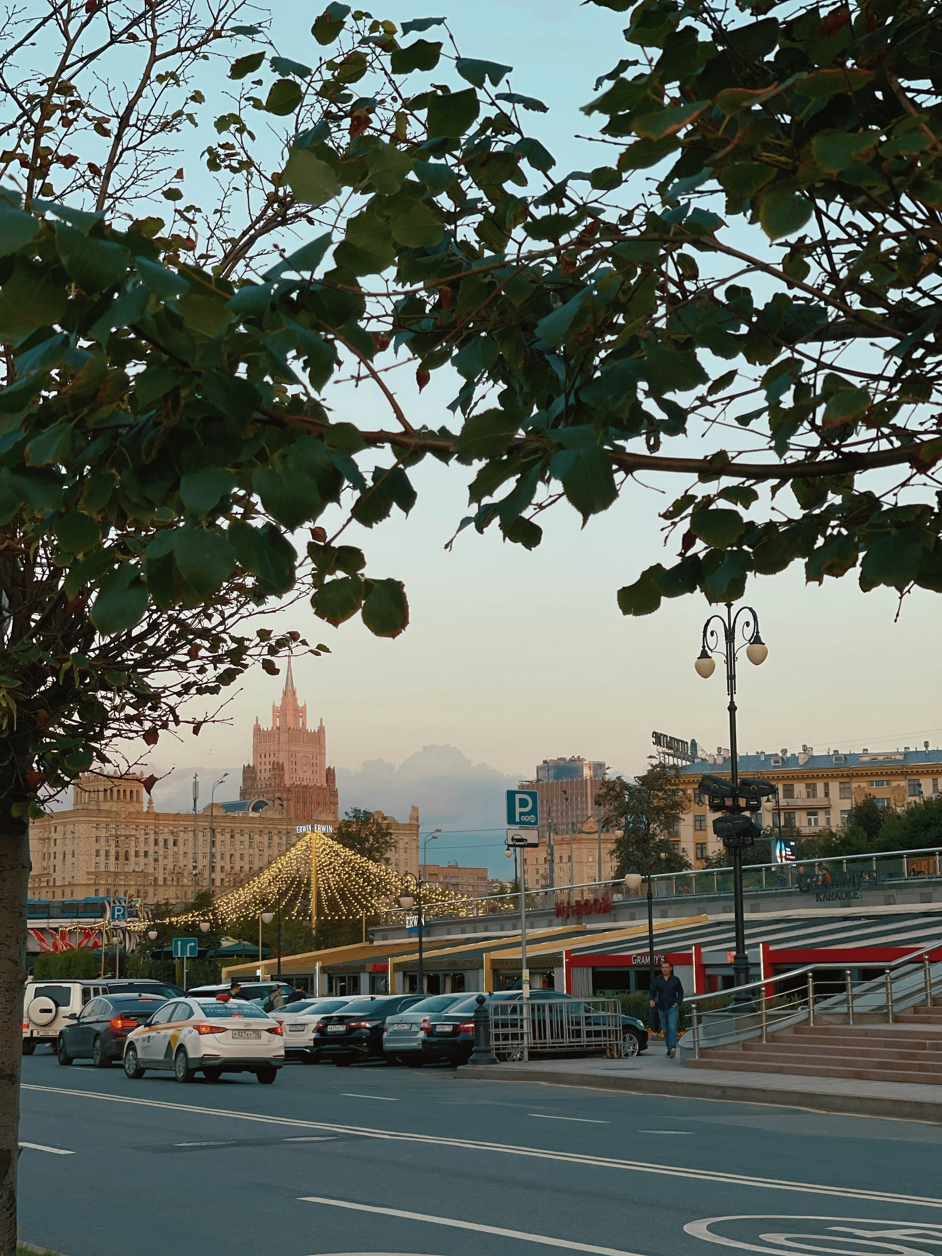 cars parked on parking lot near high rise buildings during daytime