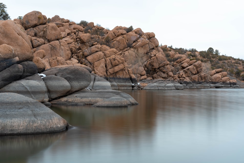 brown rock formation beside body of water during daytime