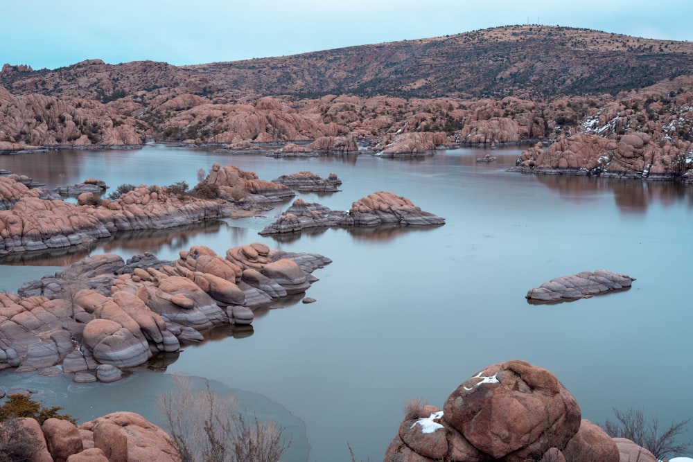 brown rock formation on lake during daytime