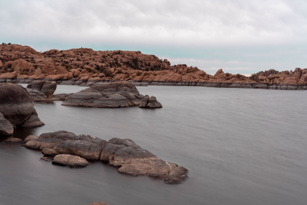 brown rock formation on body of water during daytime