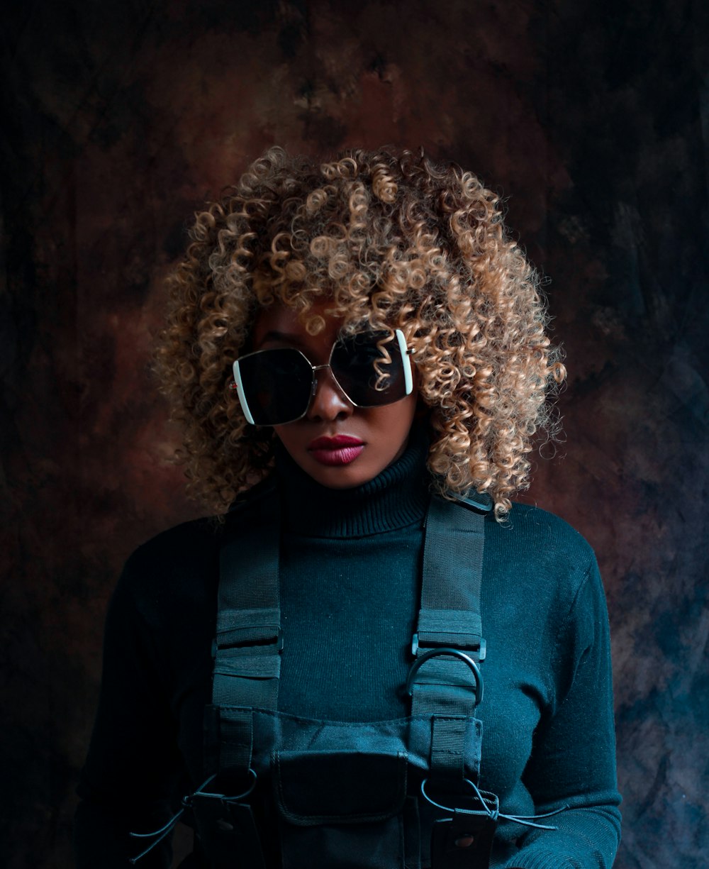 woman in purple long sleeve shirt wearing black sunglasses