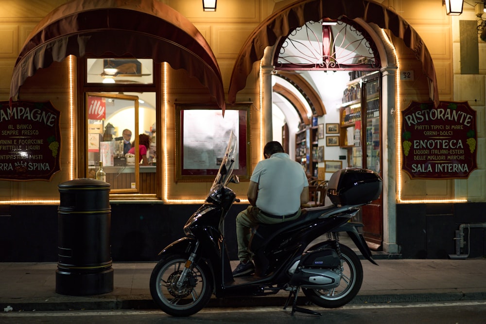 man in white shirt riding black motorcycle