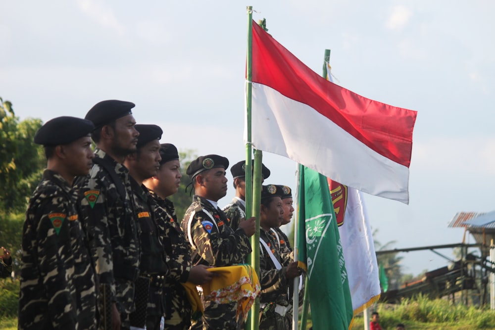 people in black and yellow uniform holding flags during daytime