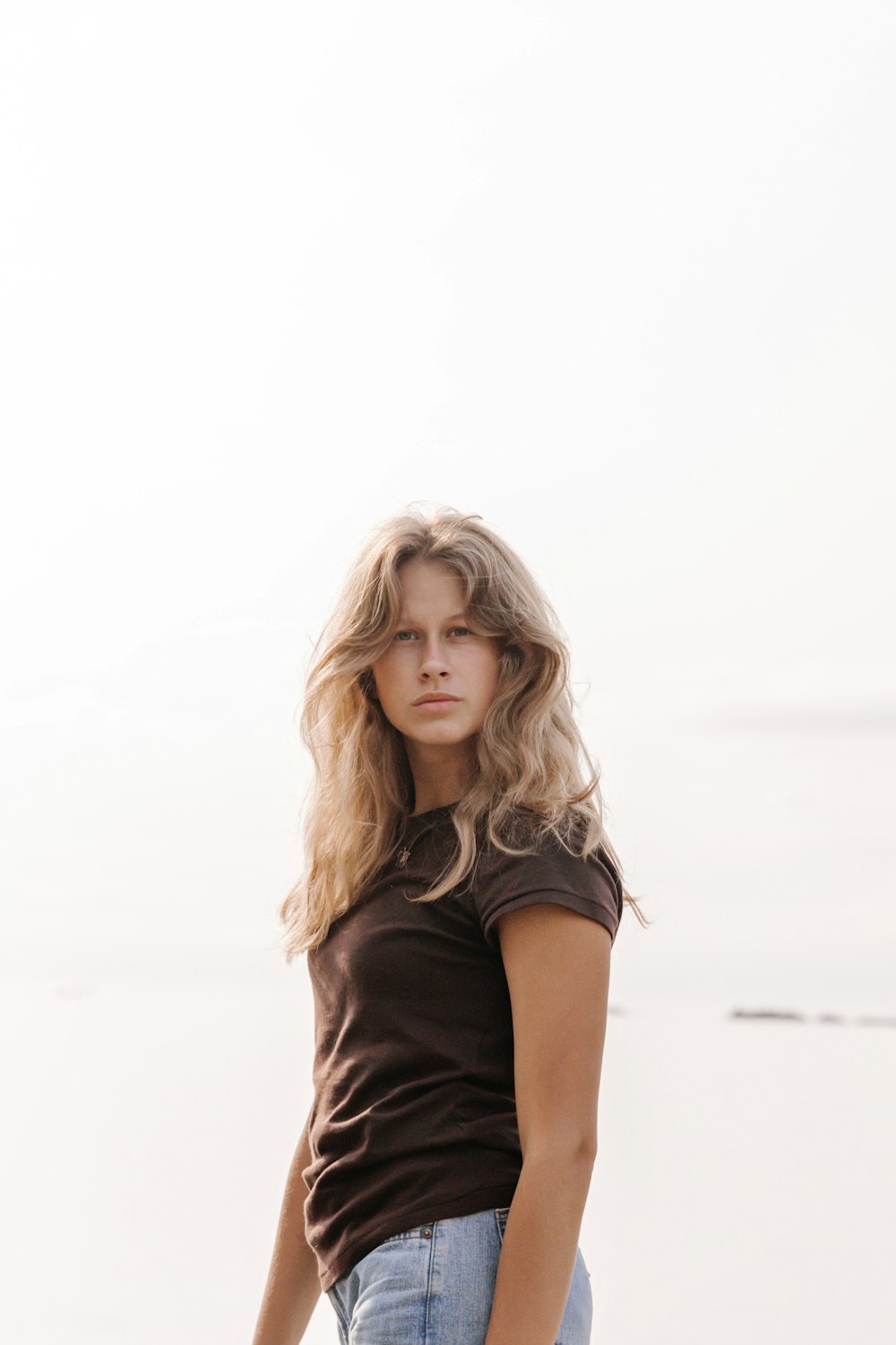 woman in black t-shirt standing on beach during daytime