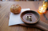 A rustic wooden table set with bowls of spicy sauces and freshly baked bread.