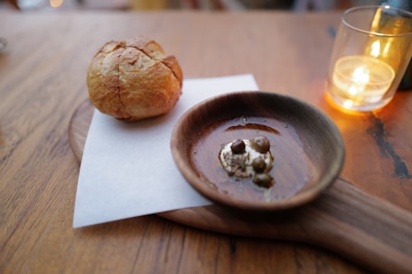 A rustic wooden table set with freshly baked bread and a side of dipping oil.