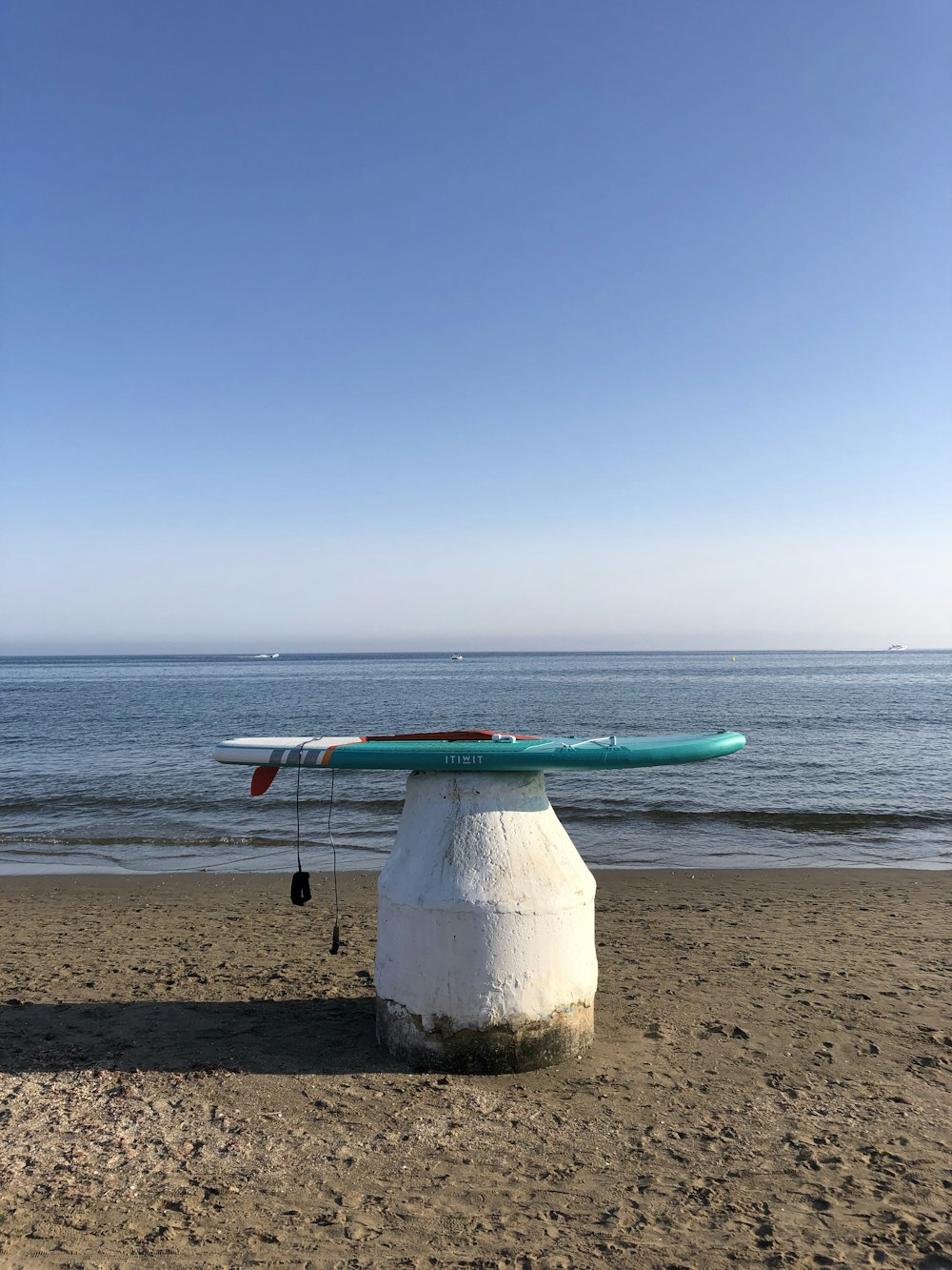 white and green surfboard on beach during daytime