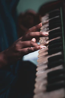 A serene moment of a singer tuning their harmonium backstage before a Punjabi concert