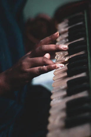 Close-up of a peaceful hand gently holding a small harmonium instrument.