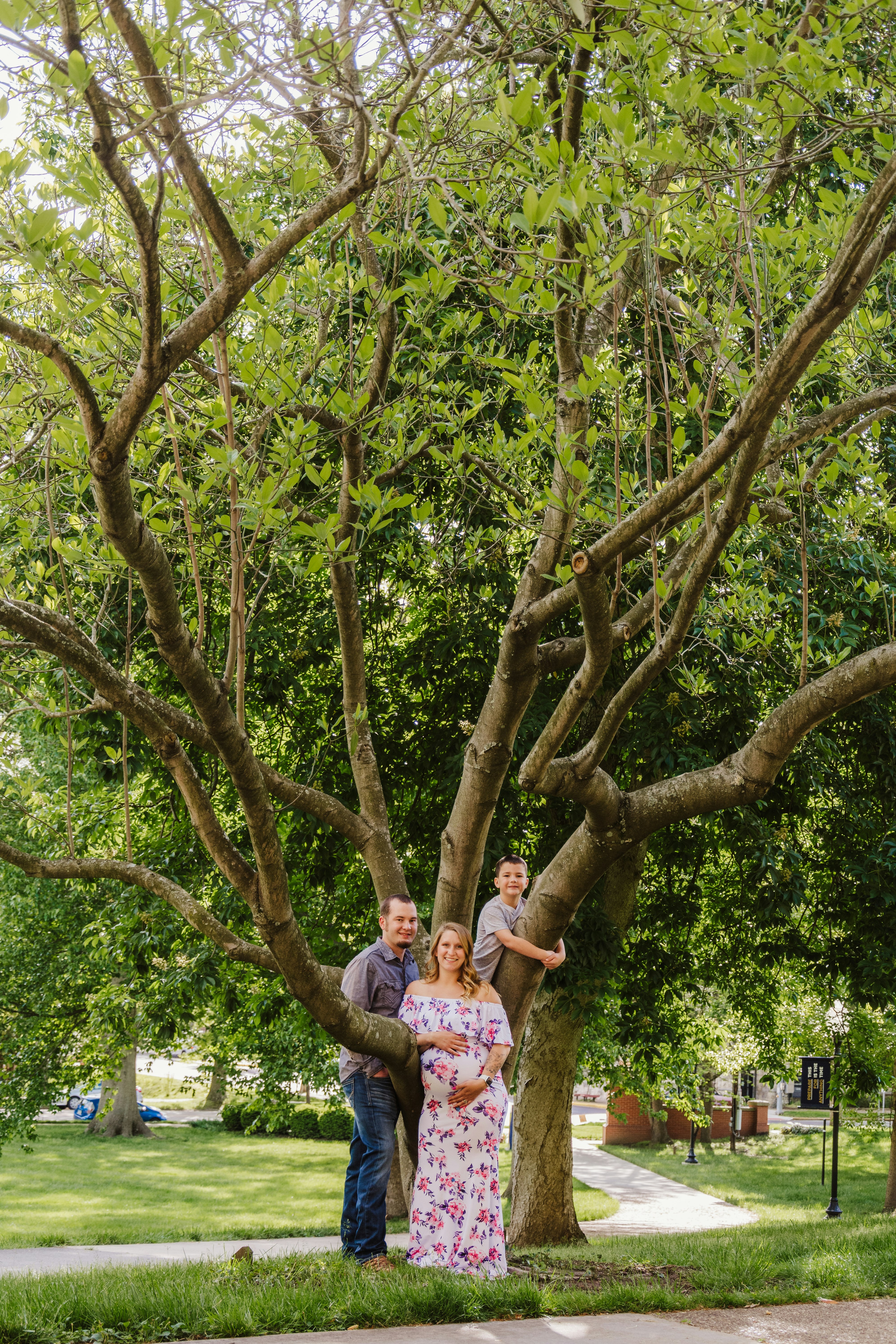 man in blue and white floral button up shirt standing under green tree during daytime