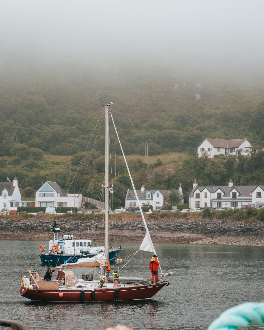 white and red sail boat on body of water during daytime