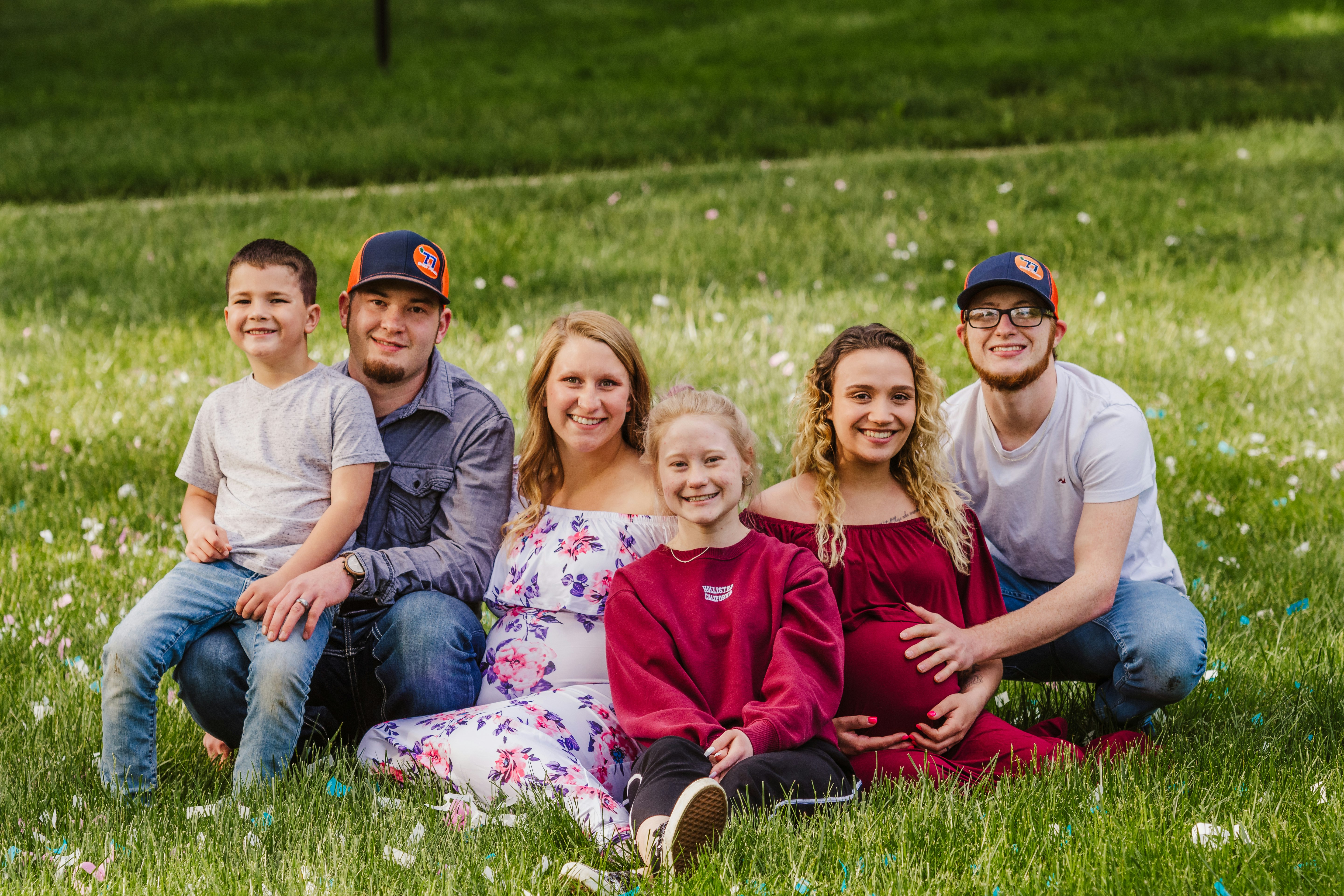 family sitting on green grass during daytime