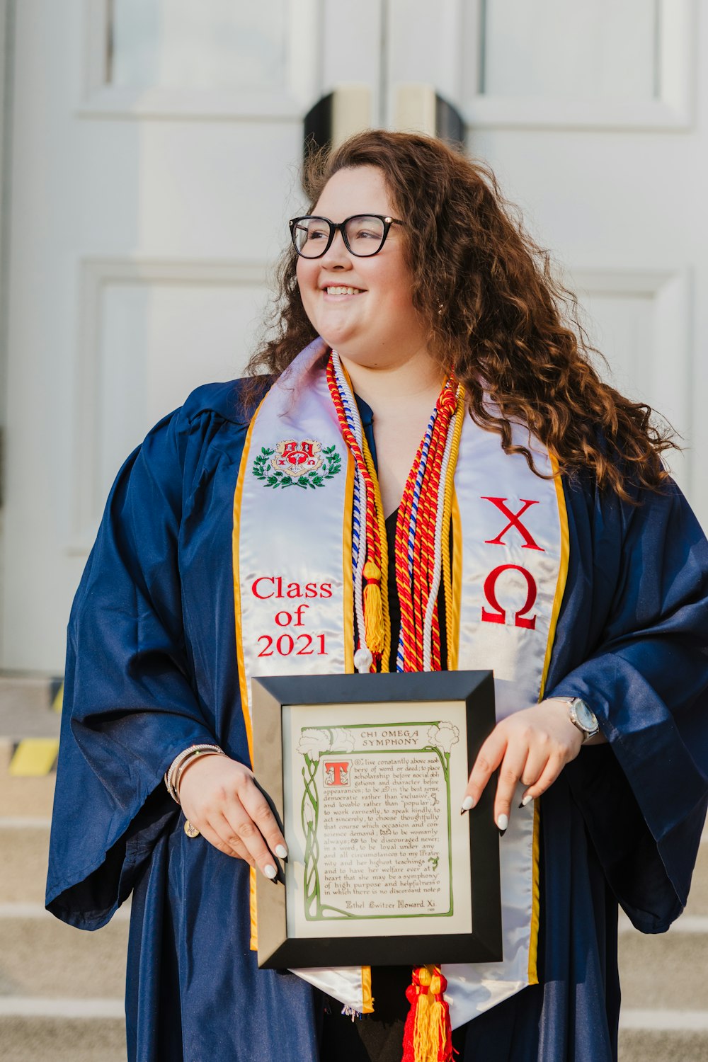 Femme en robe académique bleue et blanche détenant un certificat