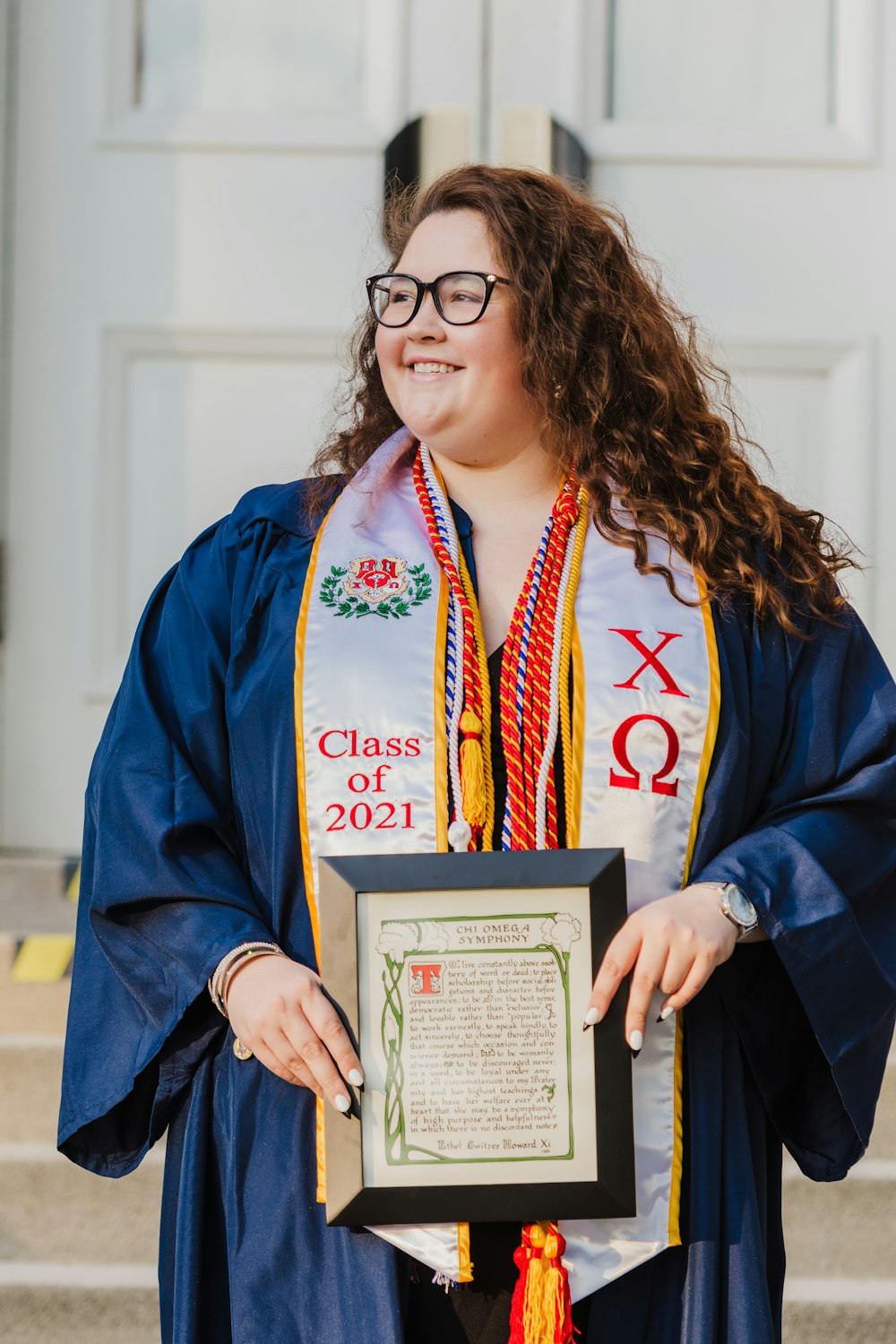 woman in blue and white academic dress holding certificate