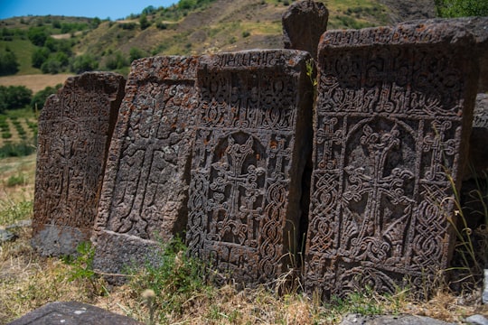 brown concrete building on green grass field during daytime in Arates Armenia