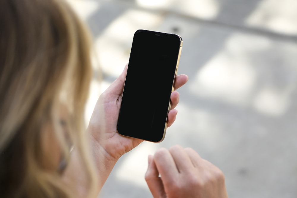 woman holding black iphone 5