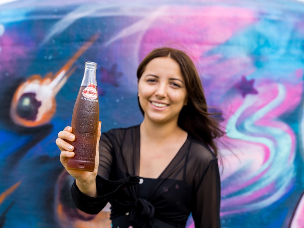 woman in black blazer holding bottle