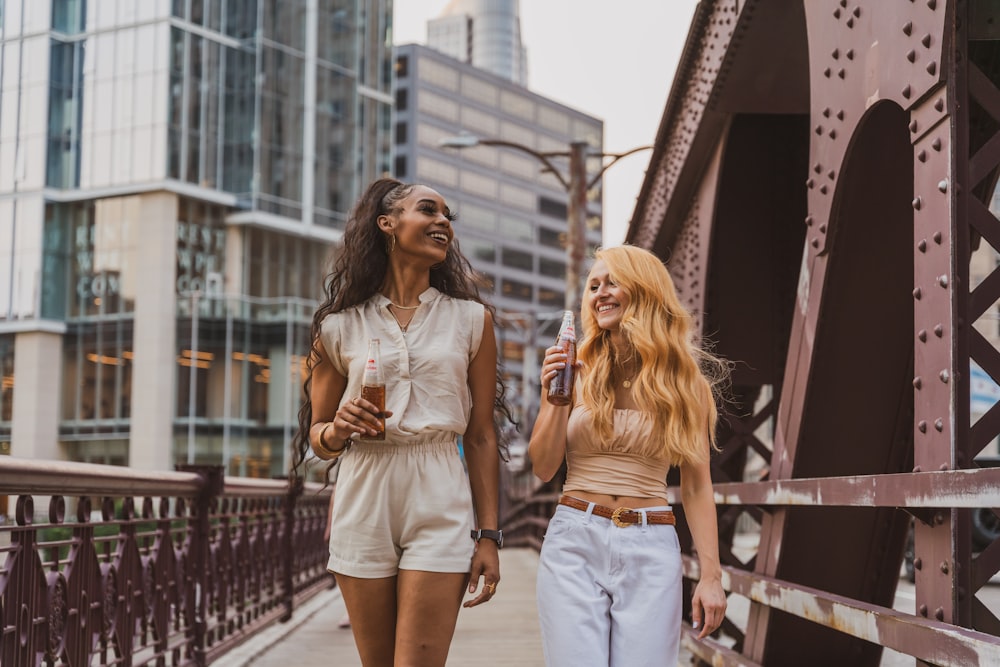 2 women standing beside red metal railings during daytime