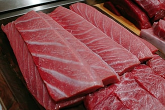 Close-up of fresh tuna steaks glistening on ice, highlighting their vibrant color and freshness.