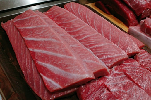 Close-up of fresh tuna steaks glistening on ice, highlighting their vibrant color and freshness.