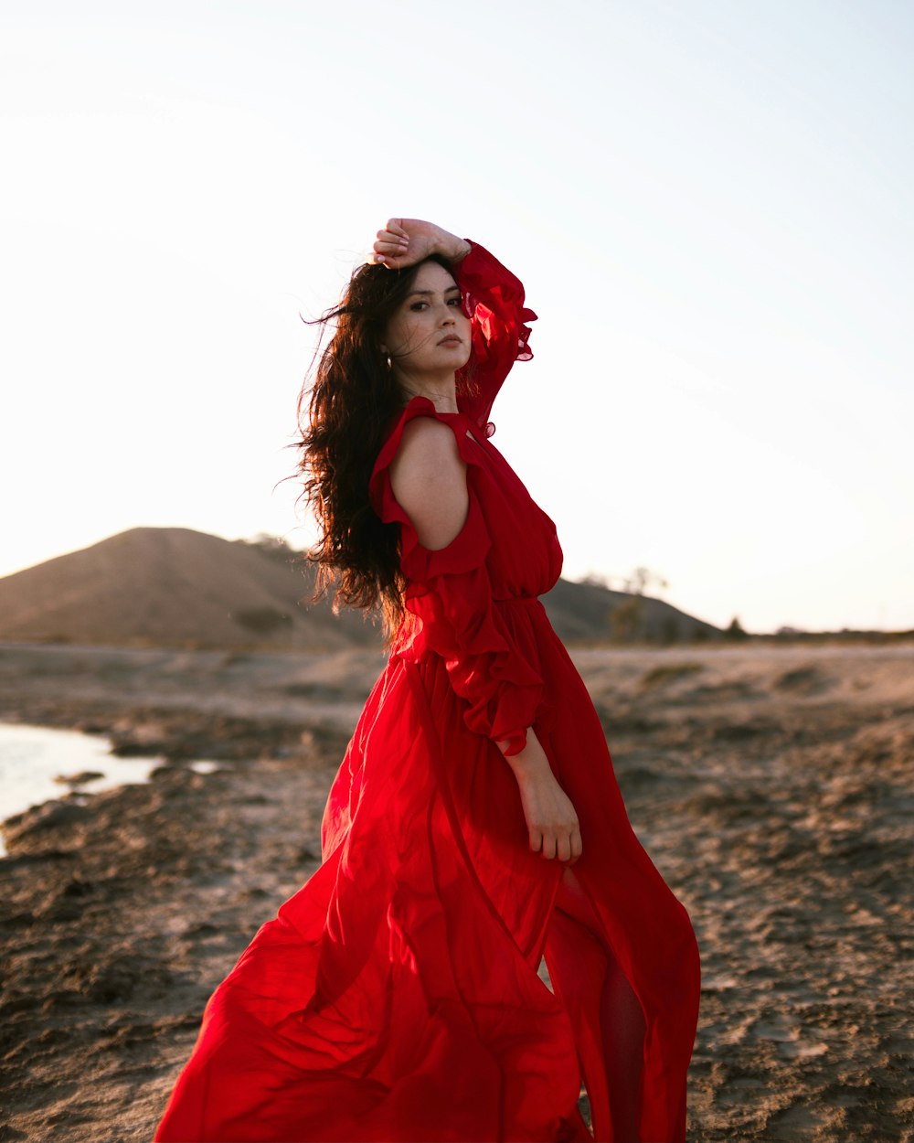 woman in red dress standing on brown sand during daytime