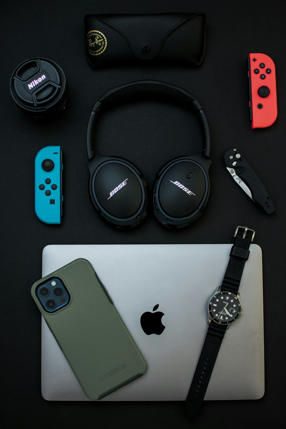 Schwarze Sony-Kopfhörer neben silbernem iPhone 6 und schwarz-silberner Uhr