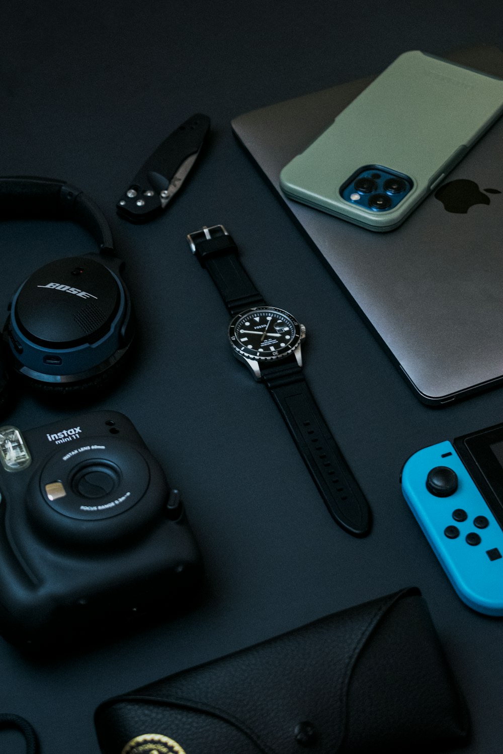 black and silver round analog watch beside silver iphone 6 and black and silver round watch