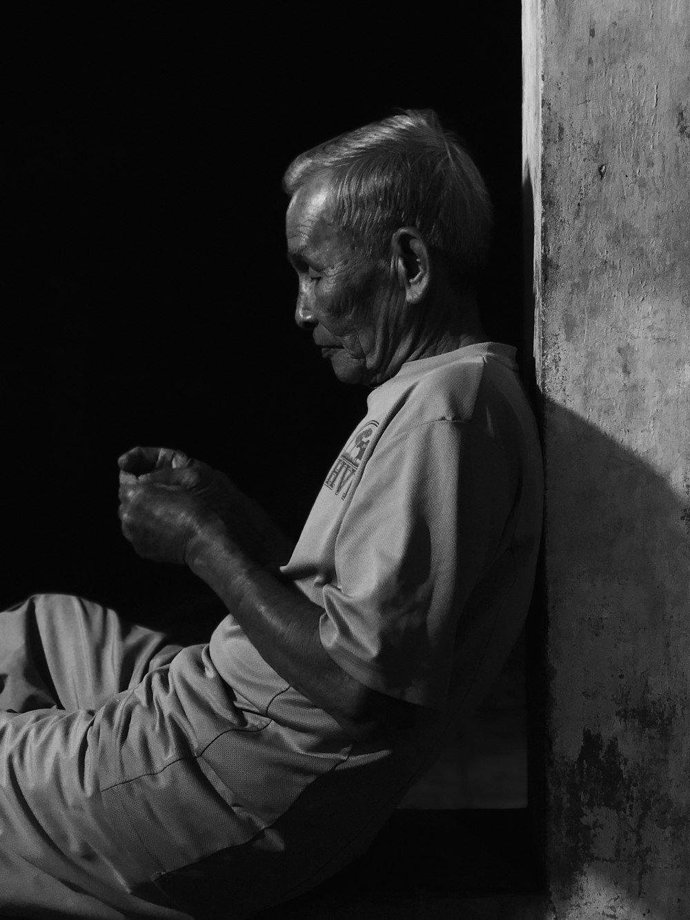 man in white dress shirt leaning on wall