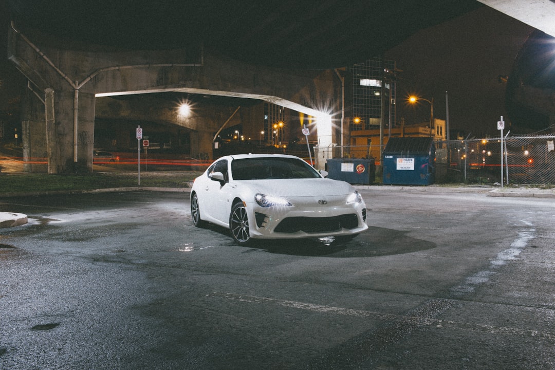 white coupe on gray asphalt road during night time