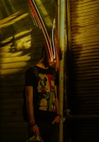 Detail shot of a t-shirt’s bold graphic design illuminated by streetlight reflections on a gritty city wall.