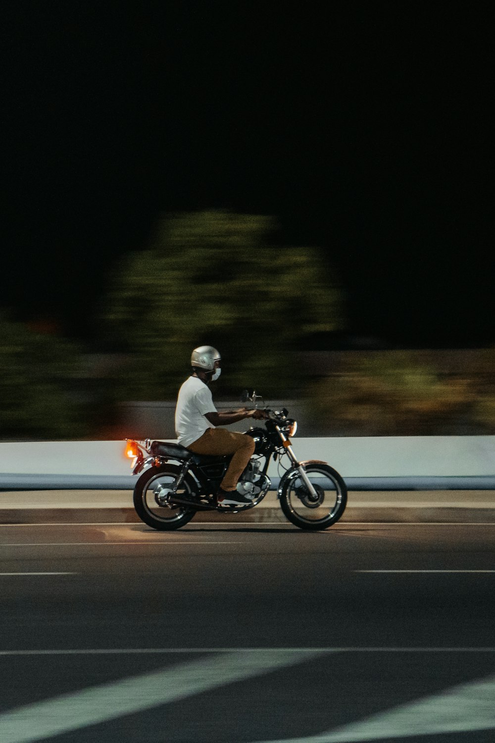 昼間の道路でバイクに乗る男