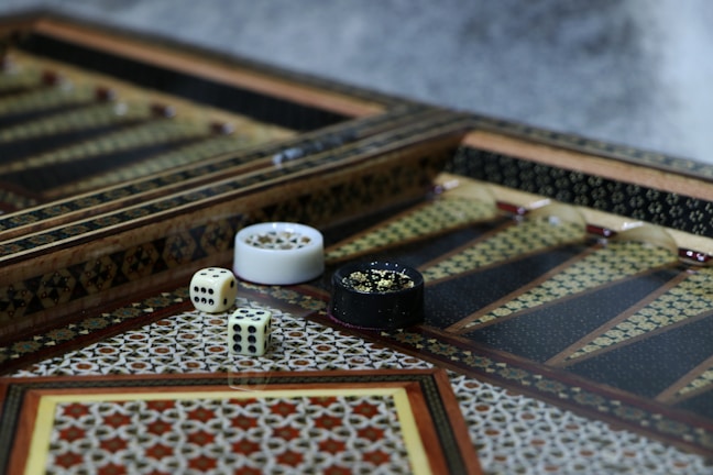 A close-up of a beautifully carved wooden board game set on a rustic table