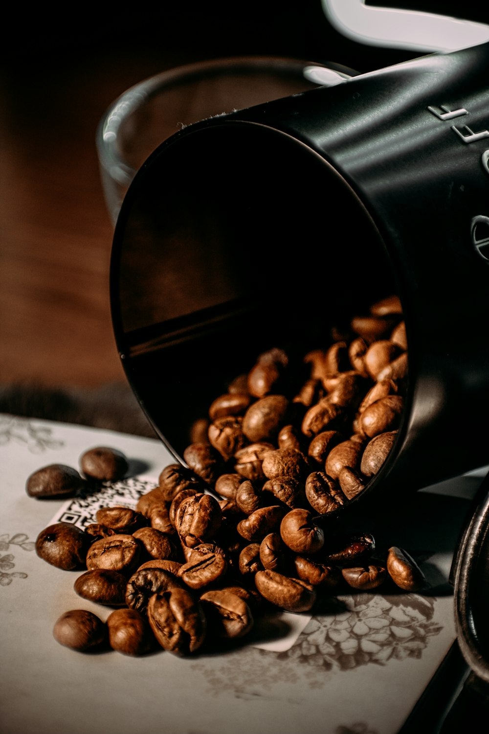 grãos de café em copo de vidro transparente