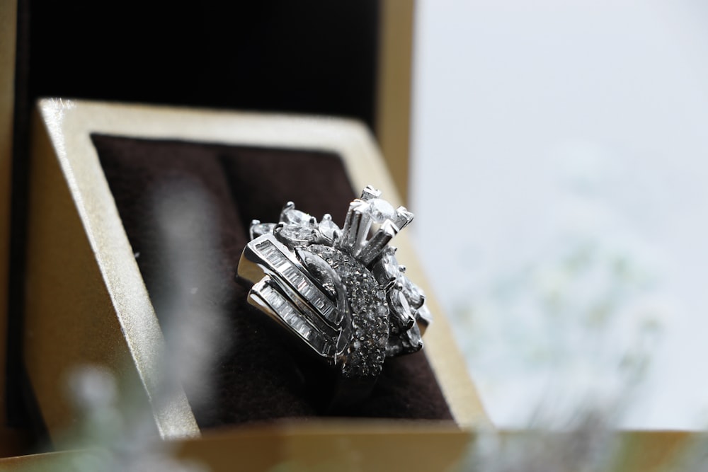 silver diamond ring on box