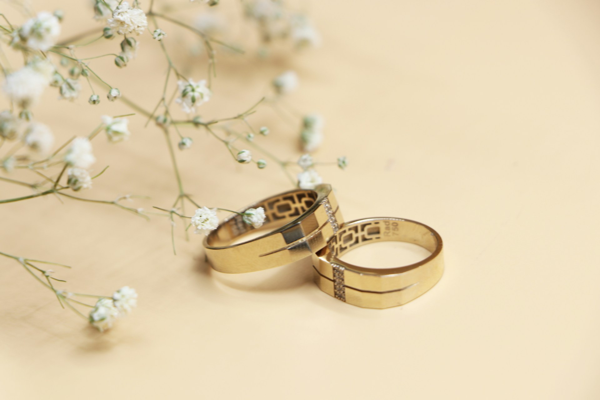 Two solid gold wedding bands resting on warm linen