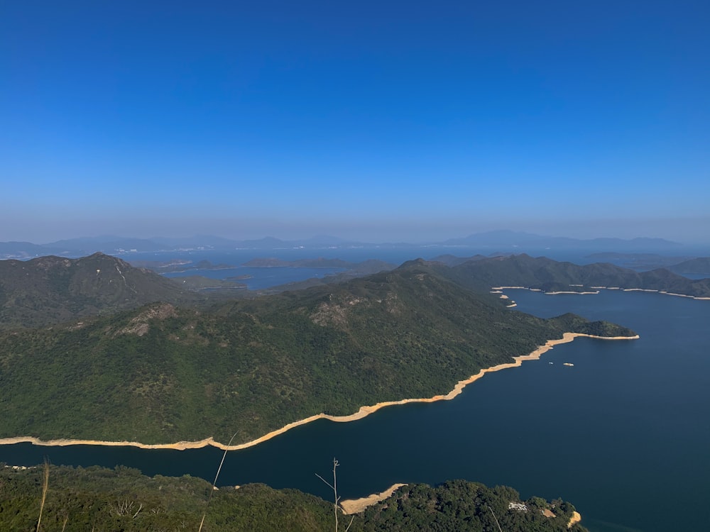 green and brown mountains near body of water during daytime