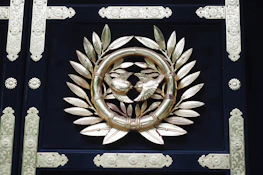 An elegant navy and gold emblem subtly inspired by freemasonry symbols on a cream background.