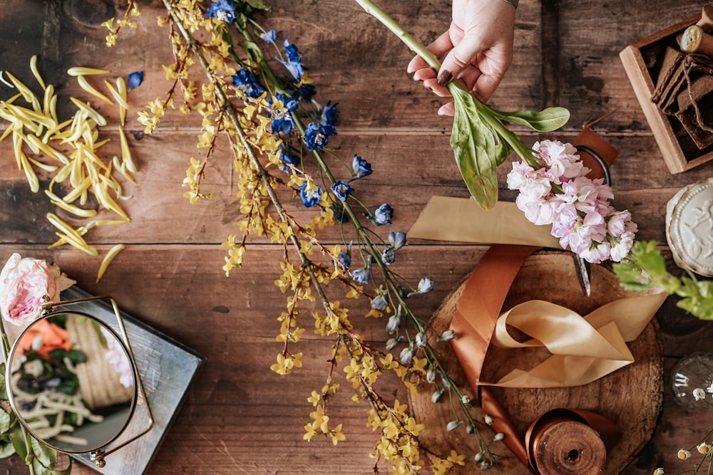 person holding blue and white flowers