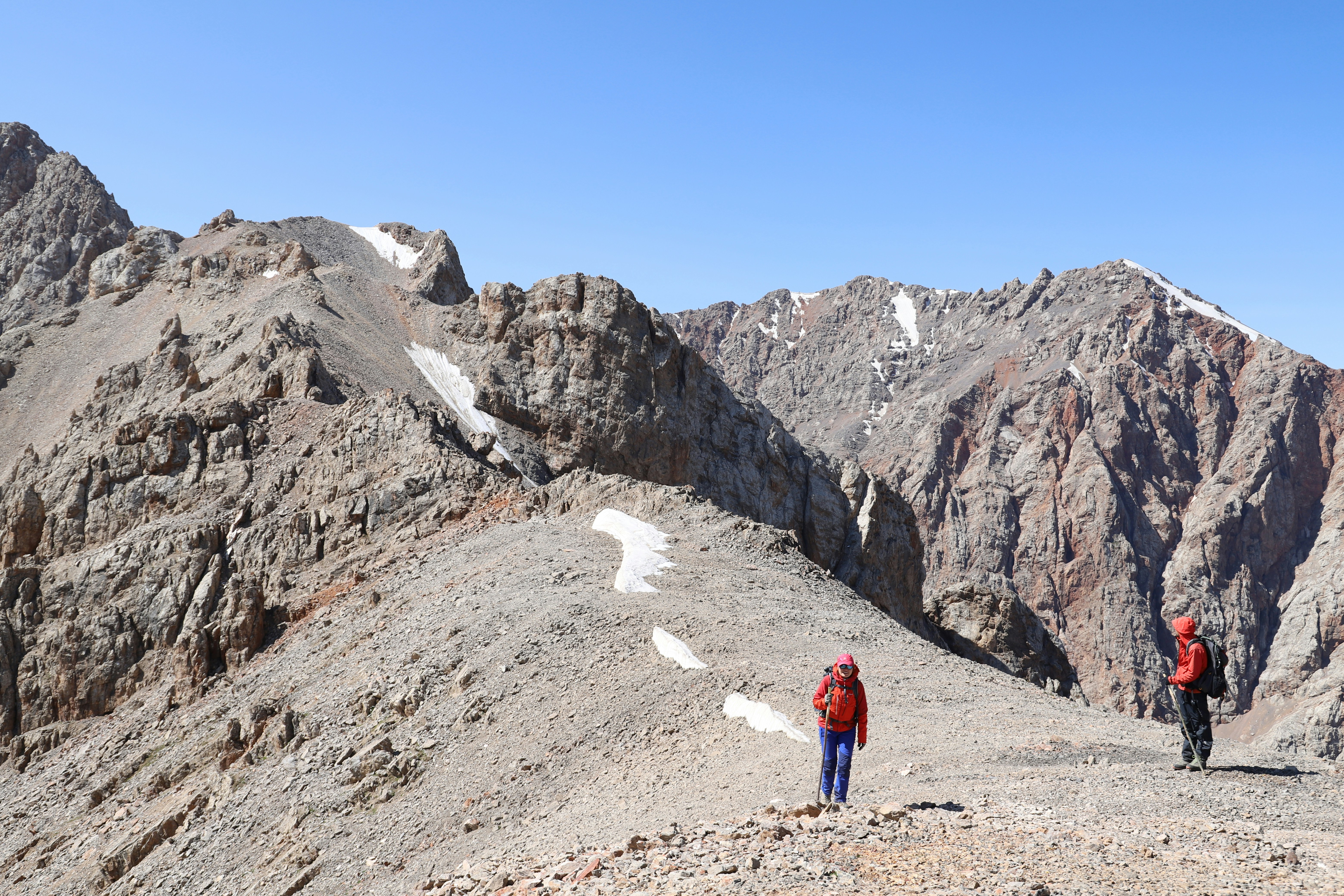 person in red jacket standing on brown field during daytime