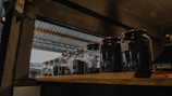 Rows of glass jars filled with various specialty coffee beans lined up against a dark concrete wall.