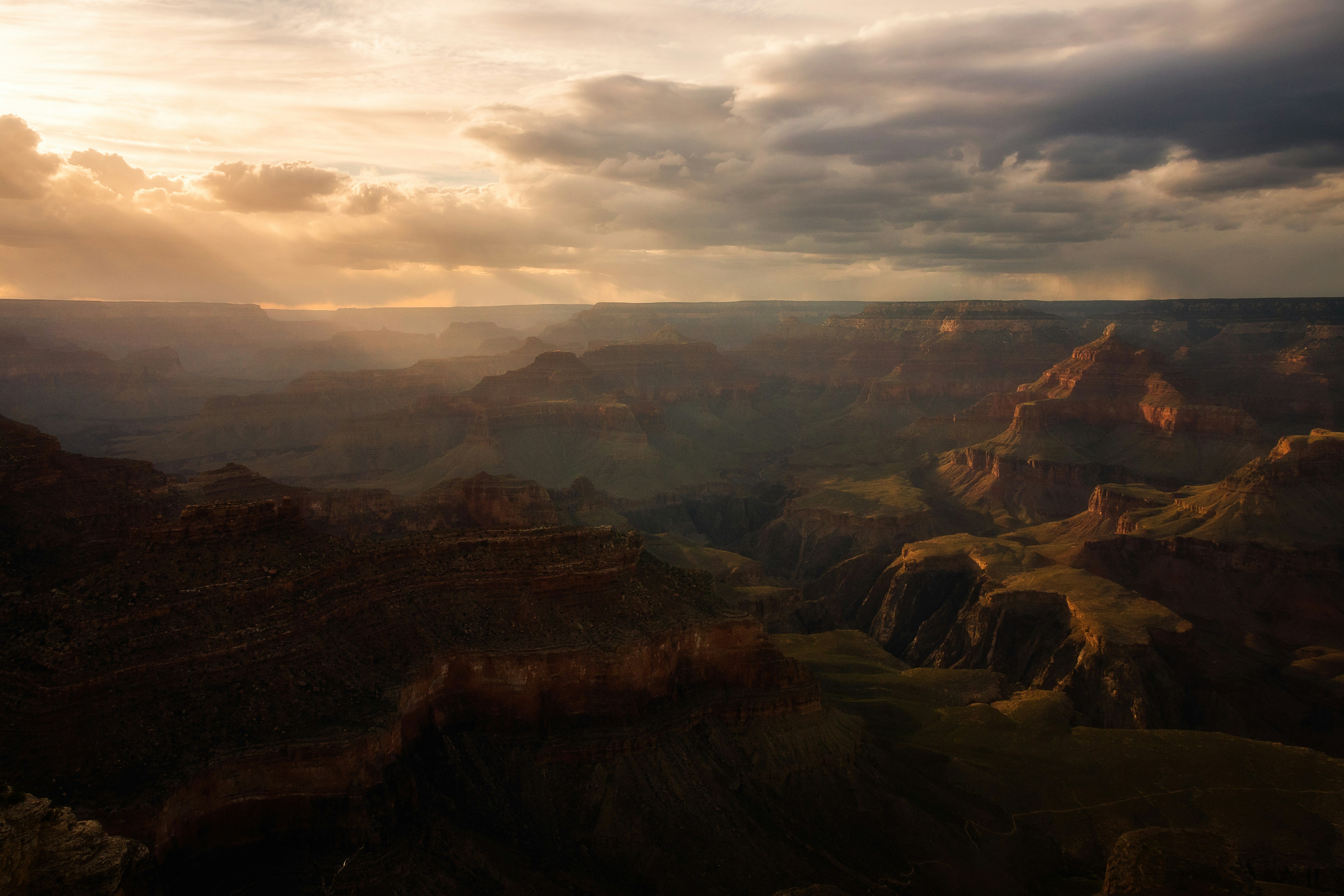 montagne rocheuse brune sous ciel nuageux pendant la journée