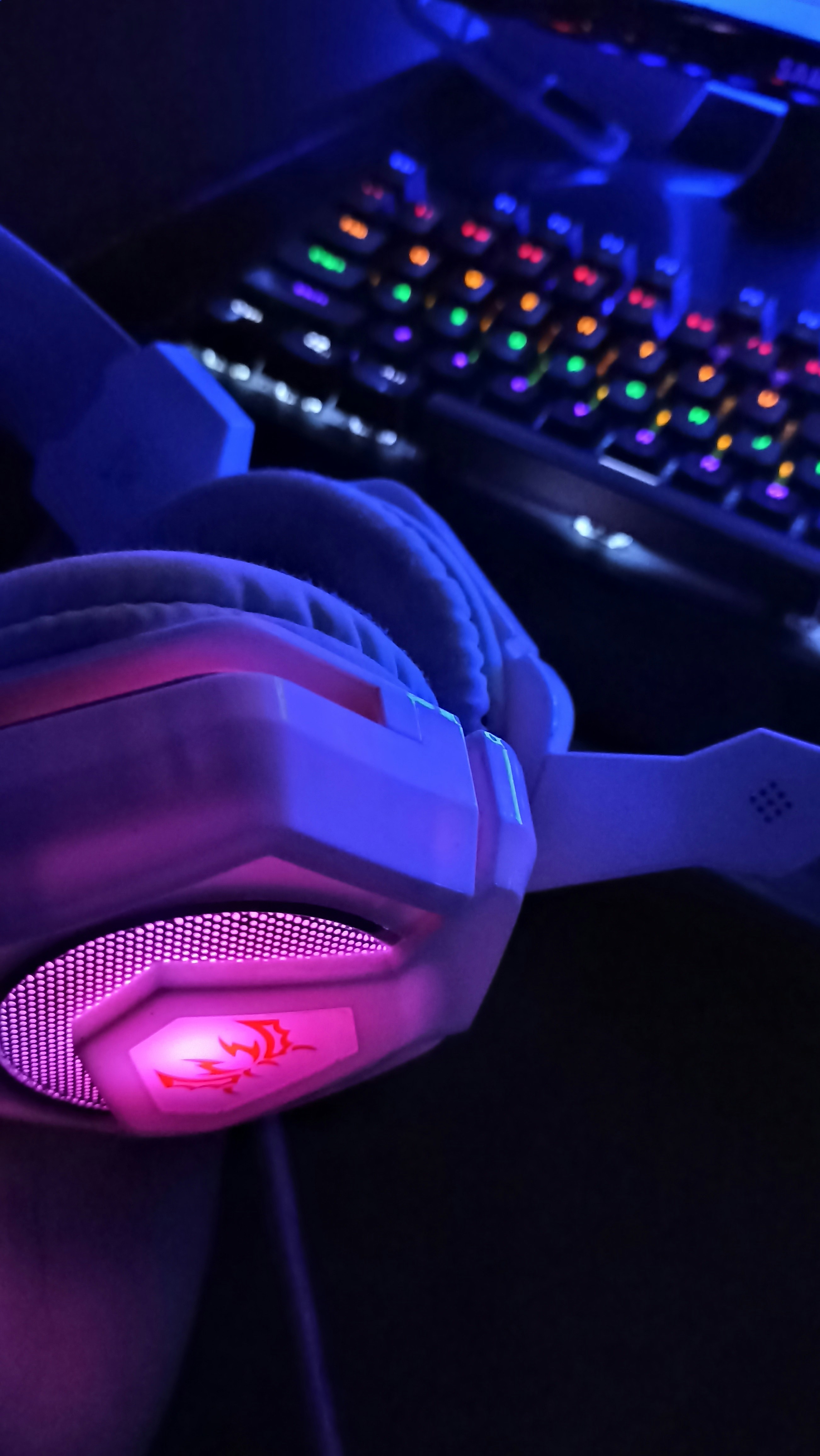 Headset gamer com iluminação RGB em fundo escuro, produto novo disponível na loja